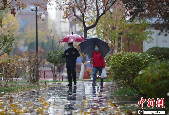 资料图：市民雨中出行。　于晶 摄