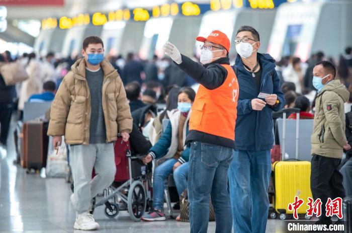 杭州东站铁路志愿者为旅客指引检票口方向。　曹志刚 摄