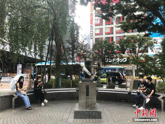 资料图:日本民众在涩谷车站前的雕塑旁休息。 <a target='_blank' href='/'>中新社</a>记者 吕少威 摄 点击进入下一页