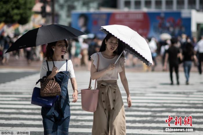 资料图:日本高温天气下的东京街头。 点击进入下一页