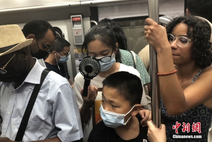 当地时间7月19日,法国首都巴黎气温突破40摄氏度。当天仍有不少民众选择乘坐地铁出行。图为在拥挤的巴黎地铁车厢内,有民众用微型风扇解暑。 <a target='_blank' href='/'>中新社</a>记者 李洋 摄 点击进入下一页