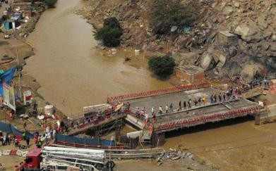 秘鲁北部遭强降雨侵袭 大量房屋被淹、卡车被困路上