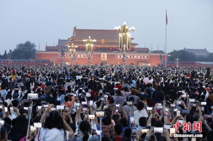 10月1日，北京天安门广场举行国庆升国旗仪式，来自四面八方的市民游客齐聚广场，共同见证五星红旗冉冉升起的庄严时刻，庆祝新中国73周年华诞。 <a target='_blank' href='/'>中新社</a>记者 盛佳鹏 摄 　