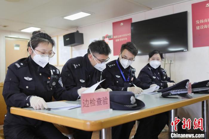 边检民警为科考人员办理边检查验手续。 上海边检总站供图 边检民警为科考人员办理边检查验手续。 上海边检总站供图
