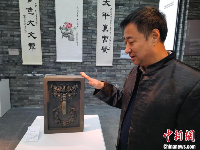 邹洪利介绍根据易县燕下都遗址出土的青铜器纹饰开发制作的龙凤纹铺首砚。 吕子豪 摄 邹洪利介绍根据易县燕下都遗址出土的青铜器纹饰开发制作的龙凤纹铺首砚。 吕子豪 摄