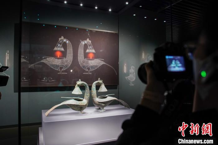 图为参观者拍摄展品“羽纹铜凤灯”。　陈冠言 摄
