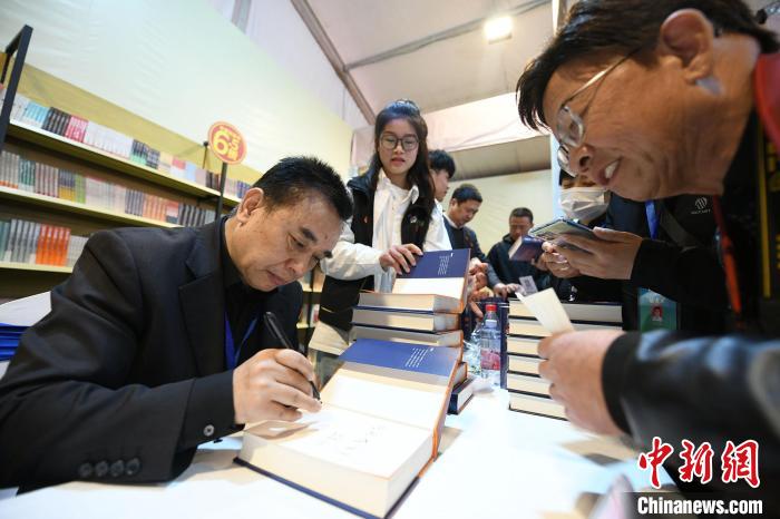 图为作家王跃文现场签名售书。 梁照曾 摄 图为作家王跃文现场签名售书。 梁照曾 摄