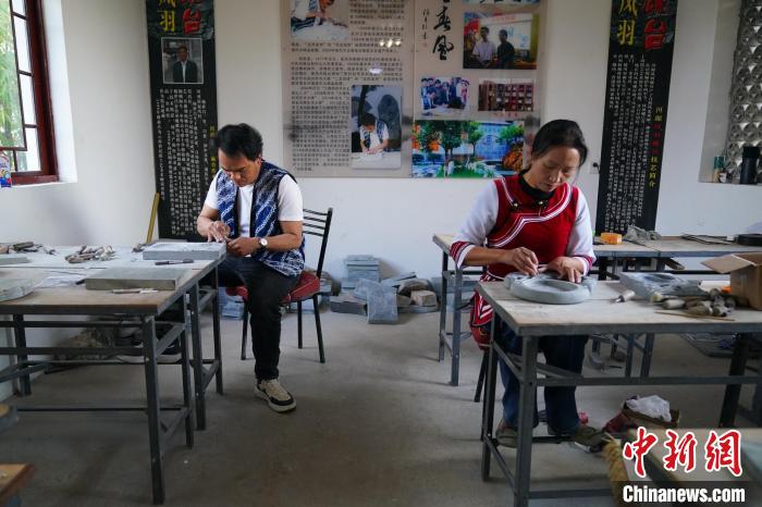 图为张跃堂和妻子正在制作凤羽砚。 刘冉阳 摄 图为张跃堂和妻子正在制作凤羽砚。 刘冉阳 摄