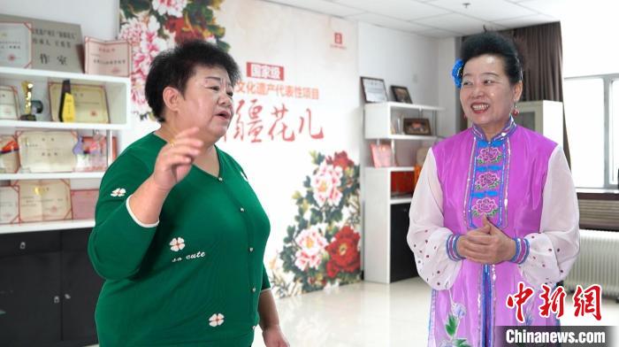 王秀芳一边唱一边向跟她学习“新疆花儿”的爱好者讲解歌词的含义 戎睿 摄 王秀芳一边唱一边向跟她学习“新疆花儿”的爱好者讲解歌词的含义 戎睿 摄