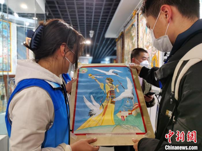 图为唐卡画师展示自己的作品。 张添福 摄 图为唐卡画师展示自己的作品。 张添福 摄