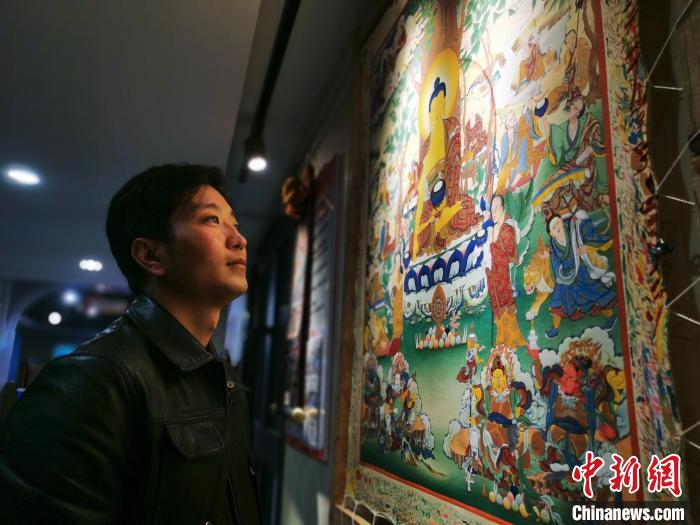 图为唐卡画师展示自己的作品。 张添福 摄 图为唐卡画师展示自己的作品。 张添福 摄