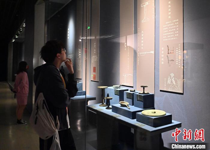 一名年轻人在吉林省博物院认真观看文物介绍。　张瑶 摄