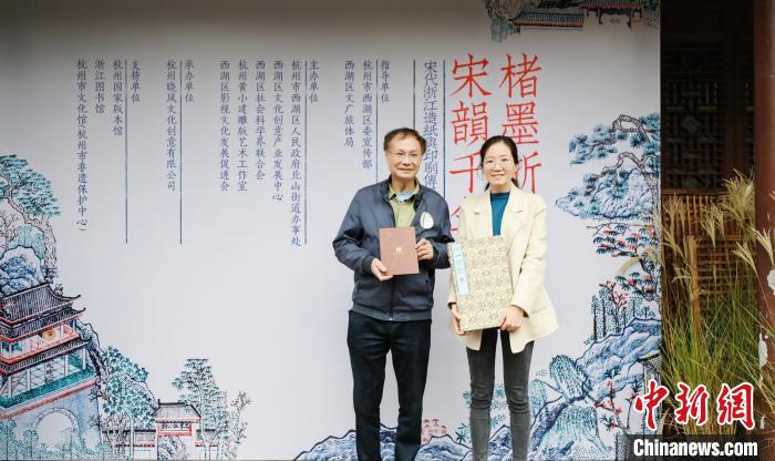 国家级非遗(杭州雕版印刷技艺)代表性传承人黄小建(左)将重新刻印的《湖山胜概》捐赠给杭州国家版本馆 晓风书屋 供图 国家级非遗(杭州雕版印刷技艺)代表性传承人黄小建(左)将重新刻印的《湖山胜概》捐赠给杭州国家版本馆 晓风书屋 供图