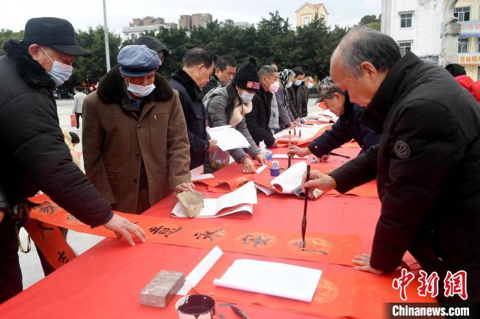 图为书法家在写春联。 廖光福 摄 图为书法家在写春联。 廖光福 摄